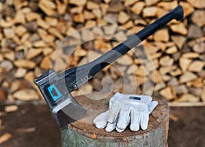 Heavy ax on the stump and protection gloves