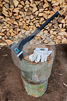 Heavy ax on the stump and protection gloves