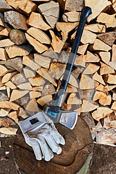 Heavy ax on the stump and protection gloves