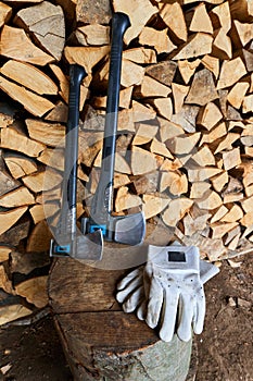 Heavy ax on the stump and protection gloves