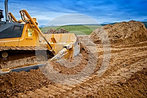 Heavy bulldozer and excavator loading and moving red sand