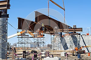 Heavy civil construction with workers placing steel bridge girders