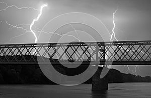 Heavy clouds bringing thunder, lightnings and storm over bridge