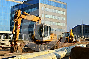 Heavy construction equipment and earthmoving excavators working on a construction site in the city.