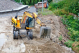 A heavy construction excavator works at a construction site to widen the carriageway