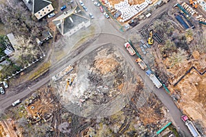 Heavy construction machines clearing out pile of debris of destroyed building after demolition. aerial view