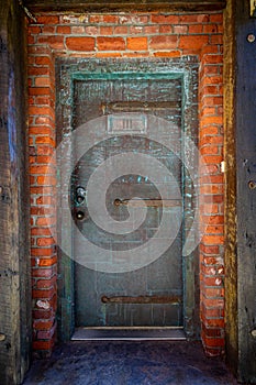 Heavy Copper Door with green oxidation entry to old brick building