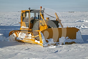 Heavy Crawler Bulldozer clears snow on the roads