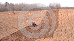 A heavy crawler tractor plows and buries a field in early spring, a plowed field for crops.