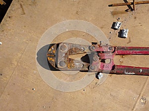 Heavy duty bolt cutter on top of old plywood formwork at the construction site.