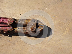 Heavy duty bolt cutter on top of old plywood formwork at the construction site.