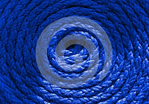 Heavy-duty bright blue coiled ships rope looking from above. Round shapes for concept copy space.