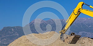 Heavy duty construction vehicle scooping up dirt