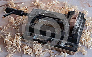 Heavy duty drill press vise / iron vice on the workbench with white wood chips all arround