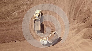 Heavy duty dump truck loaded with soil in a new construction site. Aerial view.
