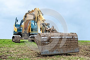 Heavy duty excavator with bucket outstretched.