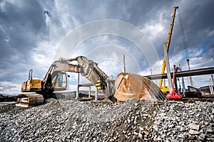 Heavy duty industrial excavator loading gravel on construction site. Details of building site