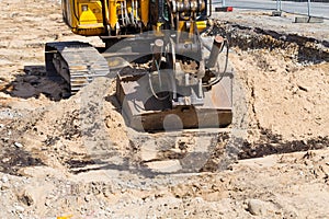 Heavy duty, industrial excavator moving soil and sand on road