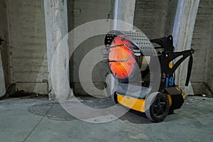 Heavy duty industrial heater blowing hot air in cold building interior. Heat compressor or heat fan propeller, propelling warm air
