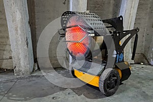 Heavy duty industrial heater blowing hot air in cold building interior. Heat compressor or heat fan propeller, propelling warm air