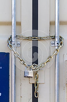 A heavy duty industrial size padlock was attached to steel chains at the entrance of an outdoor container