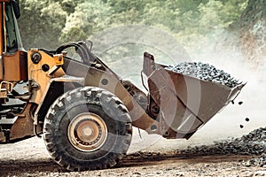 Heavy duty industrial wheel loader loading granite rock and  ore at crushing and sorting plant