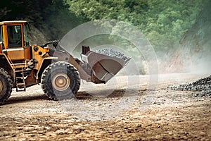 Heavy duty industrial wheel loader loading granite rock and  ore at crushing and sorting plant