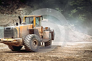 Heavy duty industrial wheel loader loading rock and  ore at crushing and sorting plant. Quarry details