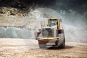 Heavy duty industrial wheel loader loading rock and  ore at crushing and sorting plant. Quarry details