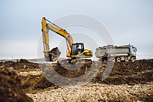 Industrial heavy duty machinery, details of excavator building highway and loading dumper trucks on construction site