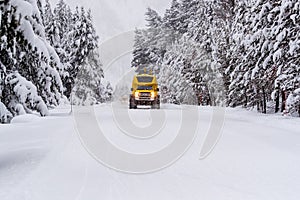 Heavy duty snow bus vehicle plows over snow of Highway 20 in Yellowstone in winter photo