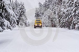 Heavy duty snow bus vehicle plows over snow of Highway 20 in Yellowstone in winter