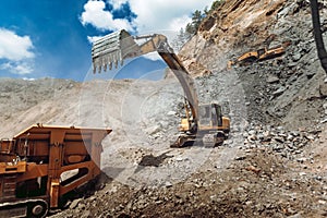 Mining industry - Heavy duty Track type excavator loading granite rock or ore quarry crushing and sorting plant