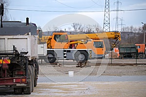 Heavy duty truck and mobile lifting crane at construction site