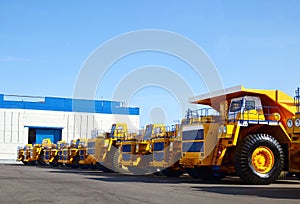 Heavy-duty trucks warehouse at autoworks. Giant mining dump trucks manufacture by the heavy vehicle plant.