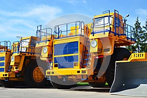 Heavy-duty trucks warehouse at autoworks. Giant mining dump trucks manufacture by the heavy vehicle plant.