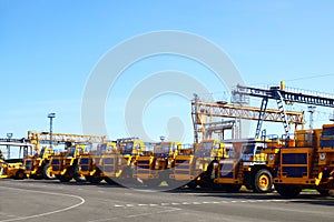 Heavy-duty trucks warehouse at autoworks. Giant mining dump trucks manufacture by the heavy vehicle plant. Heavy quarry equipment