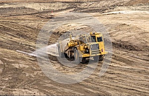 Heavy earthmoving equipment including a water truck involved in grading operations