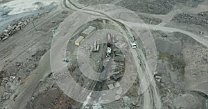 Heavy equipment digs and hauls ore inside an enormus open pit mine.