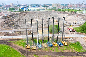 Heavy equipment for installing piles in the ground, heavy machines for driving foundation pillars are lined up. Construction
