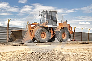 Heavy front loader or bulldozer at the construction site. Construction equipment. Transportation and movement of bulk materials.