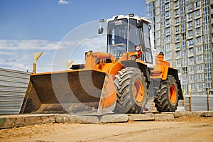Heavy front loader or bulldozer at the construction site. Construction equipment. Transportation and movement of bulk materials.