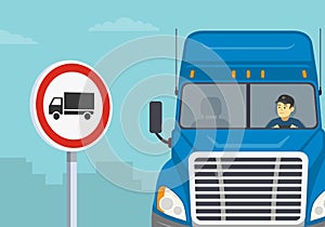 Heavy goods vehicles driving tips. Close-up view of a blue semi-trailer driver and traffic or road sign.