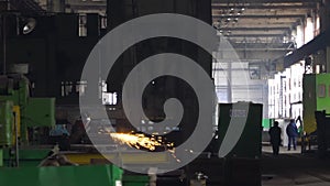 Heavy Industry Engineering Factory Interior with Industrial Worker Using Angle Grinder and Cutting a Metal Tube.