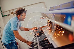 Within heavy industry. A man works in a modern factory on a CNC machine. Selective focus