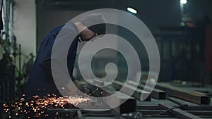 Heavy industry worker cutting steel with an angle grinder. Heavy industry manual worker