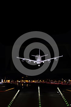 Heavy jet airliner transport landing at night with a clear sky