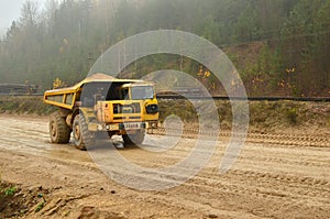 Heavy large quarry dump truck. Big wheels. The work of construction equipment in the mining industry. Production useful minerals.