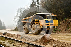 Heavy large quarry dump truck. The work of construction equipment in the mining industry. Production useful minerals