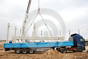 Heavy machinery lifting a concrete pillar